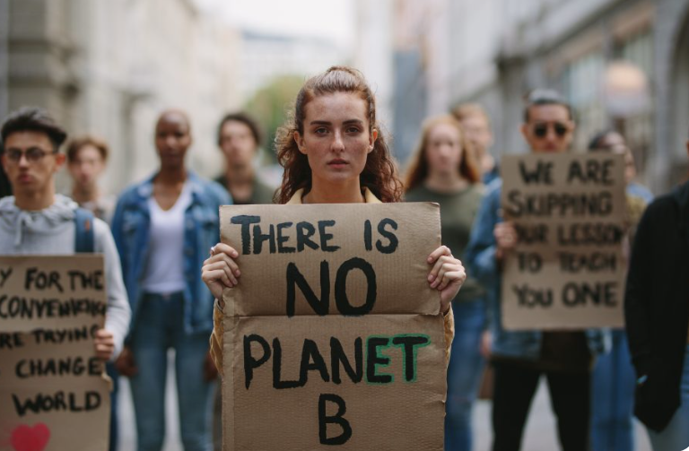 Woman holding a cardboard with "There is no Planet B" motto